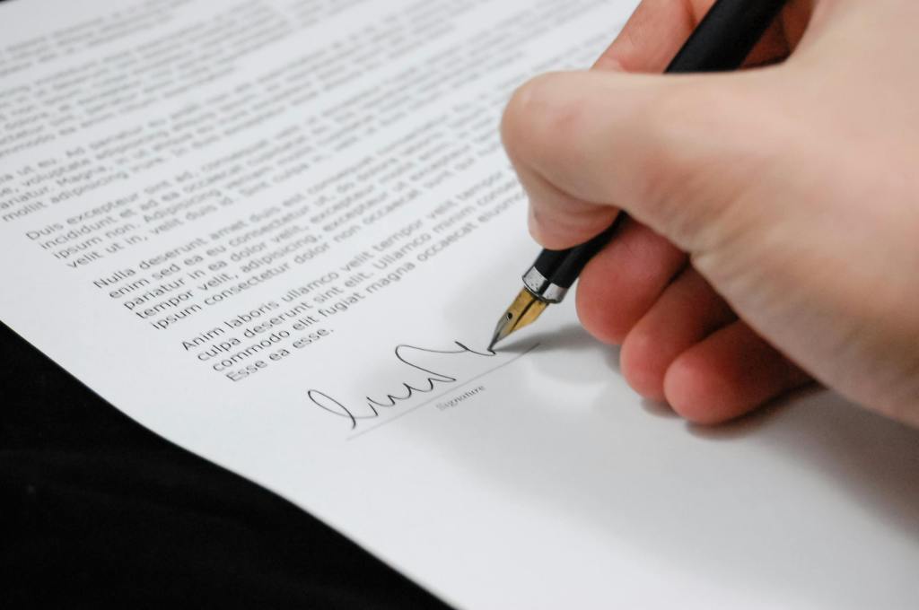 A hand signing a legal document representing an estate plan crafted by the Law Office of Don Johnson.